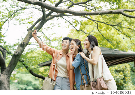 友達とスマホで写真を撮るミドル女性 104686032