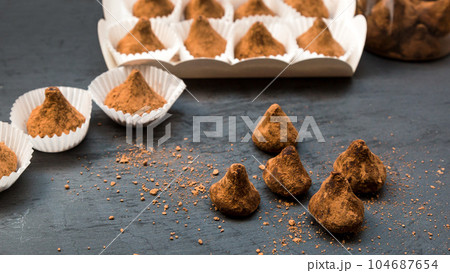 Sugar scrubs in the form of truffles in separate portion substrates for sweets on a black background 104687654