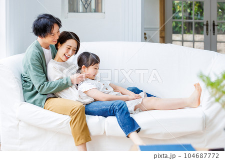 リビングのソファーに座る仲良し家族 リビングのソファーに座る仲良し家族 104687772