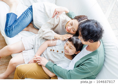 リビングのソファーでくつろぐ家族 リビングのソファーでくつろぐ家族 104687817