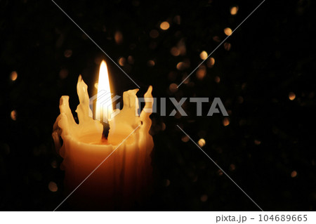 Candles Burning at Night. White Candles Burning in the Dark with focus on single candle in foreground. 104689665