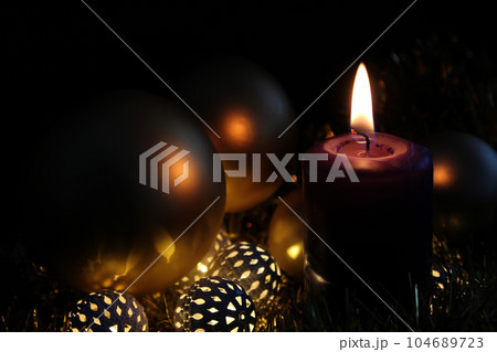 Violet candles burning in the dark, Christmas trees garland and Christmas tree toys. Table decoration for Christmas and New Year. 104689723