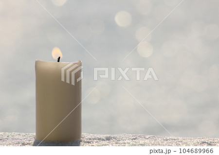 White candle on white snow background. White candle on white snow background. 104689966