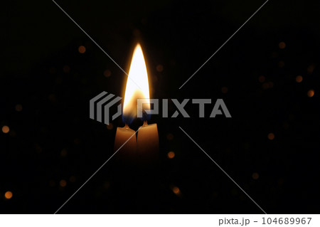 Two wax Candles Burning at Night. Yellow Candles Burning in the Dark with focus on both candles in foreground. Two wax Candles Burning at Night. Yellow Candles Burning in the Dark with focus on both candles in foreground. 104689967