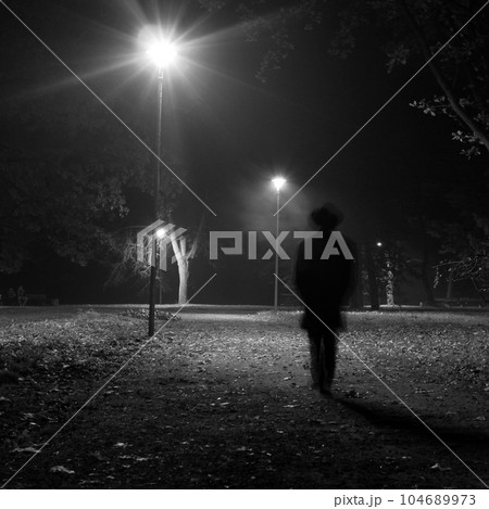 Surreal man walking in the park at night. Surreal man walking in the park at night. 104689973
