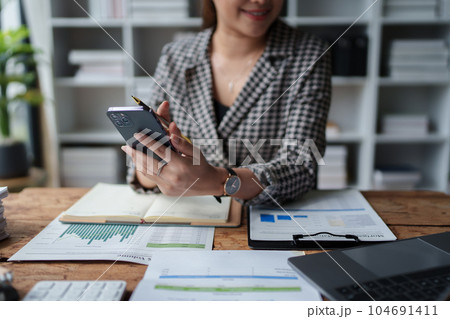 Consultant, Asian businesswoman working on the phone who discussion financial work and marketing business plan to increase company profits, ready to use computer and marketing planning documents. 104691411
