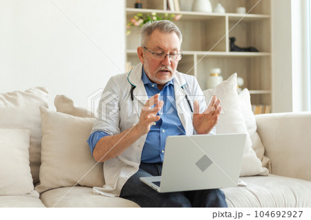 Senior man doctor with laptop talk on video call have consultation with patient. Professional senior mature healthcare expert examining patient online. Medicine healthcare medical checkup 104692927