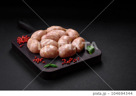 Fresh raw sausages from pork or chicken with salt, spices and herbs 104694344