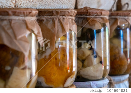 close-up of glass jars showcases a shelf of handmade canned porcini 104694821