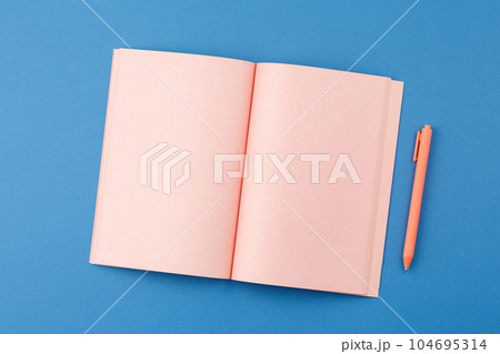 Open notepad with pen on blue background Open notepad with pen on blue background 104695314