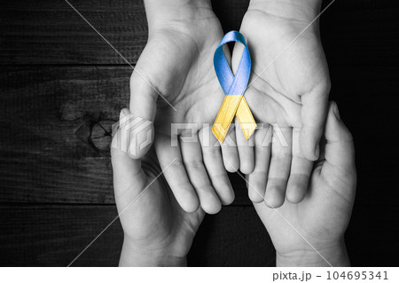children hands in male hands with ukraine ribbon children hands in male hands with ukraine ribbon 104695341