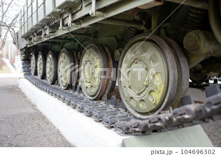Black tracks on green all-terrain vehicle wheels. Black tracks on green all-terrain vehicle wheels. 104696302