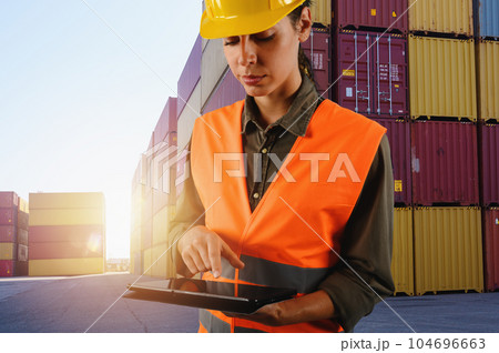 Woman works as a warehouse worker in a cargo warehouse Woman works as a warehouse worker in a cargo warehouse 104696663