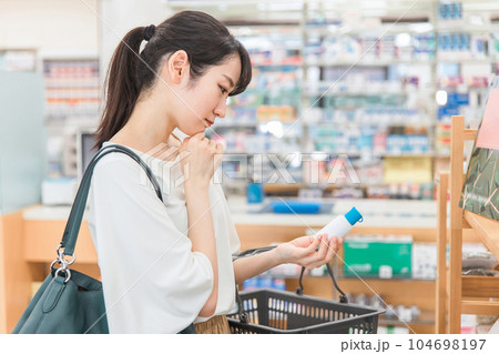 薬局・ドラッグストアで消毒液・うがい薬・洗浄液・虫除け・市販薬の買い物をする女性 104698197