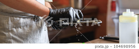 Professional chef grates Parmesan cheese on ready dish in restaurant kitchen 104698956