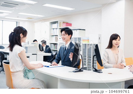 窓口で対応をするスタッフ 104699761