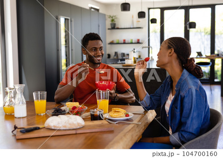 Happy african american couple enjoying breakfast in dining room Happy african american couple enjoying breakfast in dining room 104700160