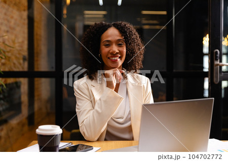 Portrait of happy african american casual businesswoman using laptop in office Portrait of happy african american casual businesswoman using laptop in office 104702772
