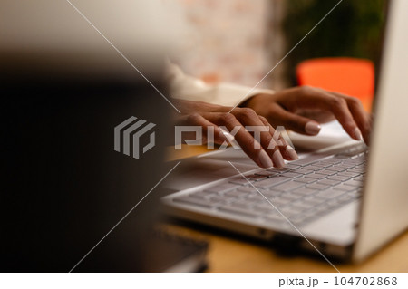 Hands of african american casual businesswoman using laptop in office 104702868