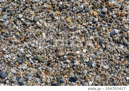Crushed stone on the seashore. Selective focus on object. The stones were laid on the ground in the garden as a background. Background blur. Pebble stones background. Crushed stone on the seashore. Selective focus on object. The stones were laid on the ground in the garden as a background. Background blur. Pebble stones background. 104703427