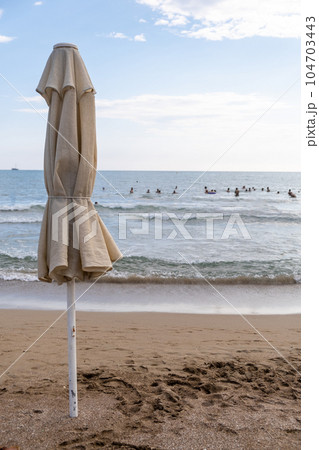 Beach in Antalya, Turkiye. Umbrellas and sun loungers in the assembled state on the beach. Beach in Antalya, Turkiye. Umbrellas and sun loungers in the assembled state on the beach. 104703443