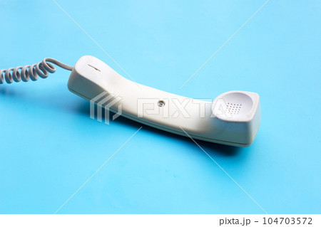 Handset of landline phone on blue background. Handset of landline phone on blue background. 104703572
