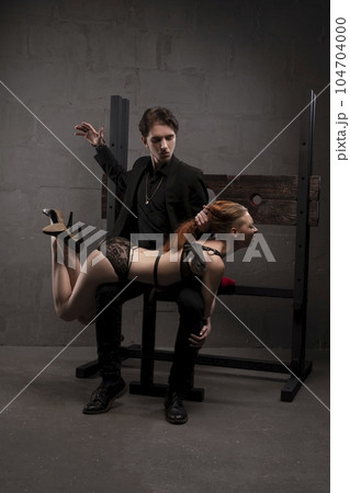 Confident man slapping woman during BDSM session 104704000
