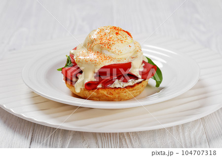 Eggs Benedict on white plate, top view Eggs Benedict on white plate, top view 104707318