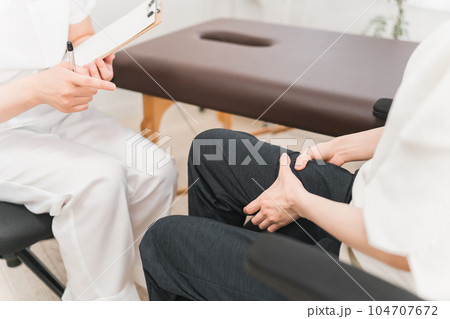 病院・整形外科で脚・太ももの怪我のリハビリ・診察をするアジア人女性医師・理学療法士・看護師と患者 104707672