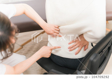 病院で腰痛・脊椎の痛みで治療を受ける患者とアジア人女性医師・理学療法士・看護師 104709292