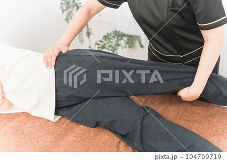 整骨院で骨盤矯正をする整体師・マッサージ師・セラピストの女性 104709719