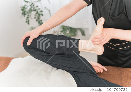 整骨院で骨盤矯正をする整体師・マッサージ師・セラピストの女性 整骨院で骨盤矯正をする整体師・マッサージ師・セラピストの女性 104709722