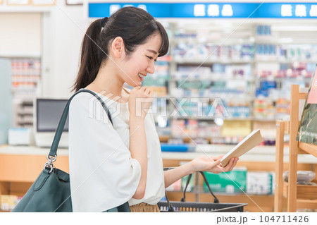 薬局・ドラッグストア・コンビニエンスストアで手帳を見ながら化粧品・コスメの買い物をする女性 薬局・ドラッグストア・コンビニエンスストアで手帳を見ながら化粧品・コスメの買い物をする女性 104711426