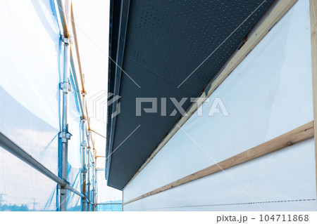 住宅新築現場の黒く塗装した棟の軒天 104711868