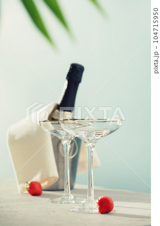Bottle of champagne and glasses on sea and sky background. Bottle of champagne and glasses on sea and sky background. 104715950