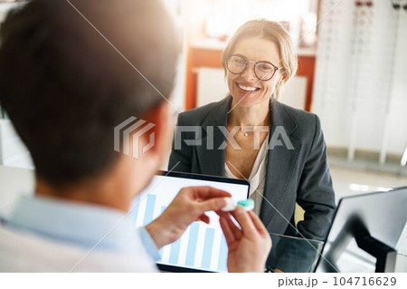Male optometrist hands giving pair of contact lens in case to patient offering choice 104716629