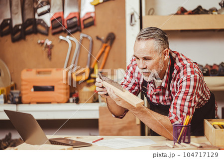 Senior professional male caucasian diy wood working making home furniture in workshop, home renovate. 104717129