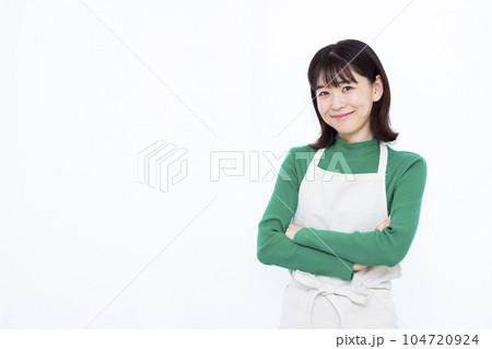 白い背景の前で腕組みをして考えている30代の主婦 104720924