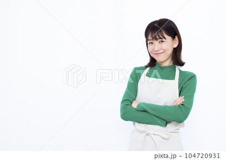 白い背景の前で腕組みをして考えている30代の主婦 白い背景の前で腕組みをして考えている30代の主婦 104720931