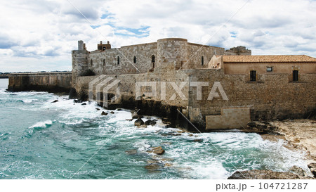 Waves break on the rocks of the castle of Ortigia in Syracuse 104721287