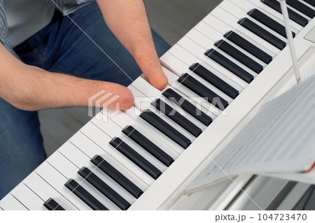 Man with amputated two hands musician is playing the piano and composes music. Man with amputated two hands musician is playing the piano and composes music. 104723470