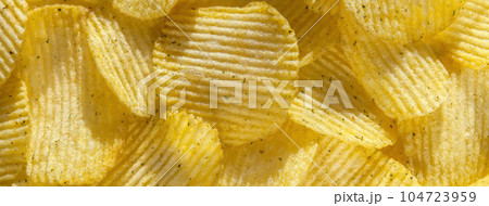Background of delicious rippled golden potato chips with onion, macro. Food backdrop Background of delicious rippled golden potato chips with onion, macro. Food backdrop 104723959