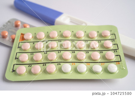 Pregnancy test and birth control pills on calendar, contraception health and medicine. 104725580