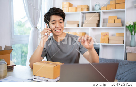 Online shopping business owner is talking on the phone with a customer to jot down the delivery address and delivery schedule, SME entrepreneur online shopping, Packaging box Sell online, Work freelan 104725716