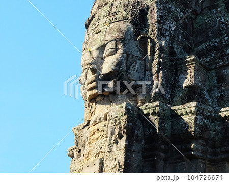 Stone face, displaying a smile, an ancient sculpture found in Cambodia. 104726674