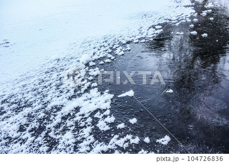 Ice on frozen pond, crystalline snow on top Ice on frozen pond, crystalline snow on top 104726836