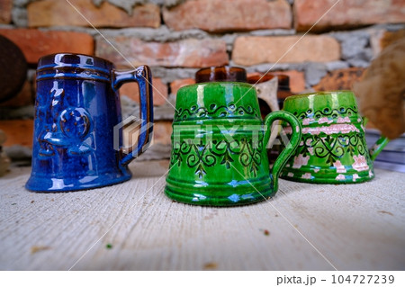 Traditional Latvian old clay cups. Cups of different sizes and colors 104727239