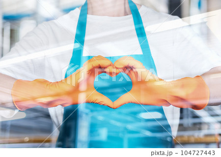 Cleaning lady gesturing heart outside the window. 104727443