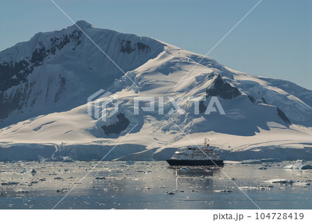Cruise ship sailing in front of Antarctic mountains, Paradise Bay, Antartica. 104728419
