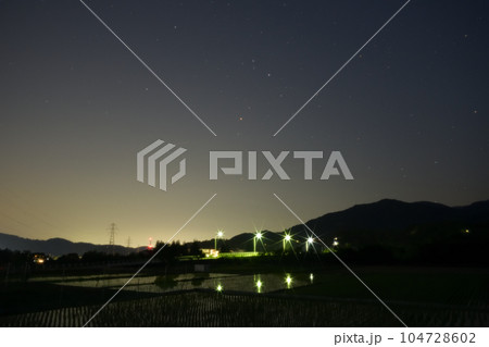 北杜市武川町、夜の始め頃、舞鶴橋の上に昇った赤い星アンタレス。水田に映る外灯 104728602